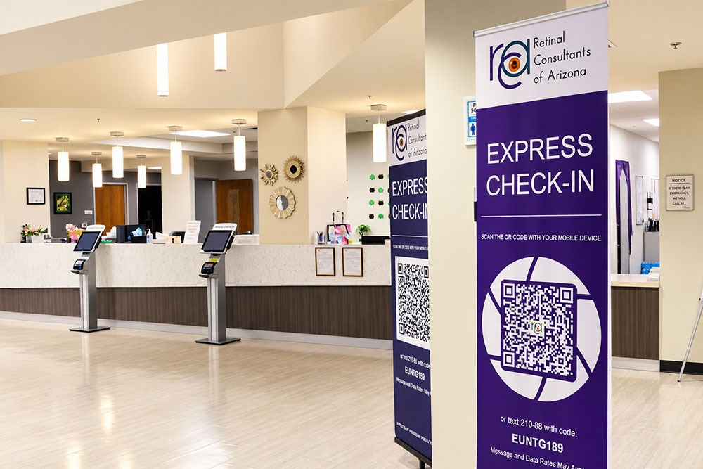 Bright, modern reception area at Retinal Consultants of Arizona featuring express check-in QR code signs, self-service kiosks, and a welcoming front desk for retina appointments.